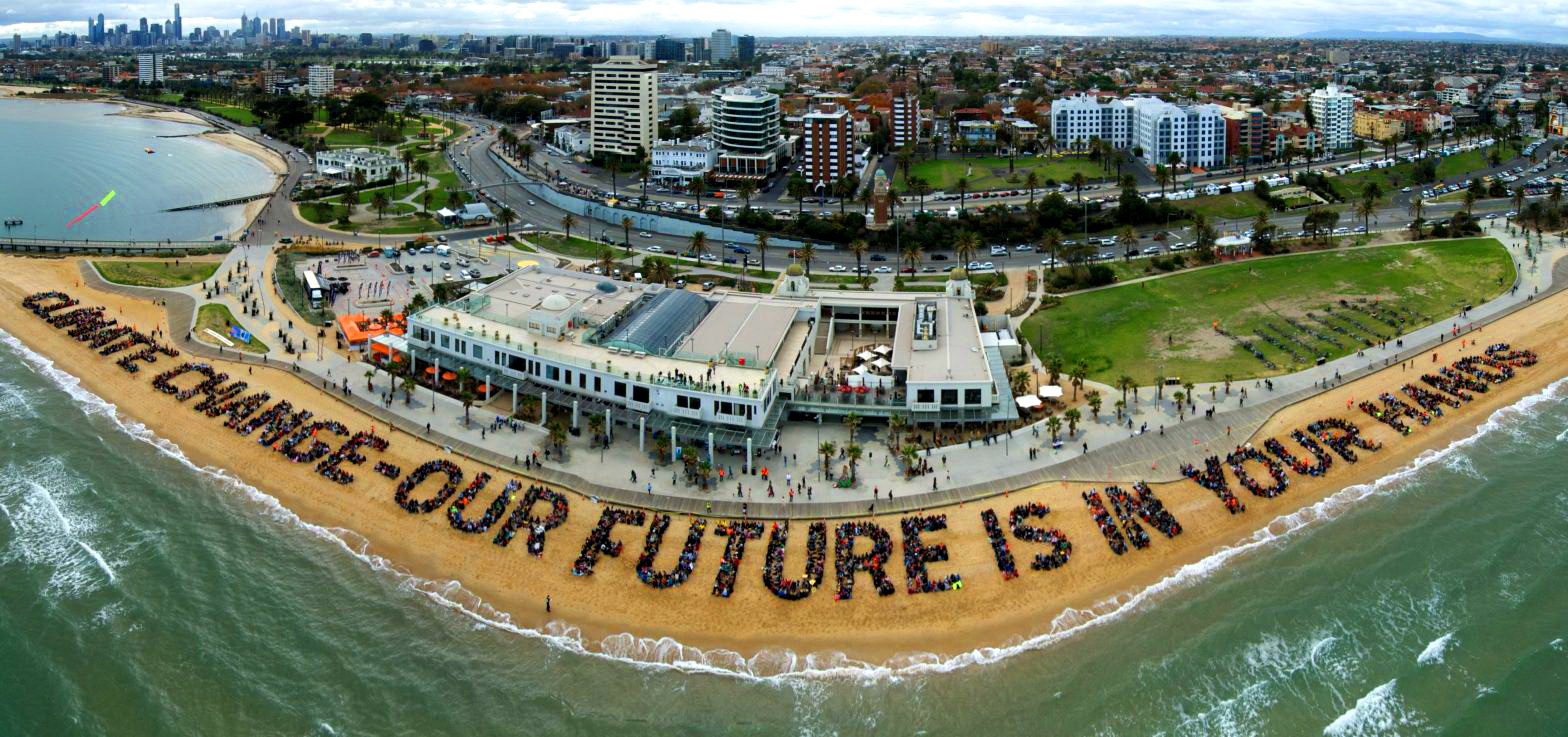 Human sign on St Kilda beach spelling out 'CLIMATE CHANGE OUR FUTURE IS IN YOUR HANDS'